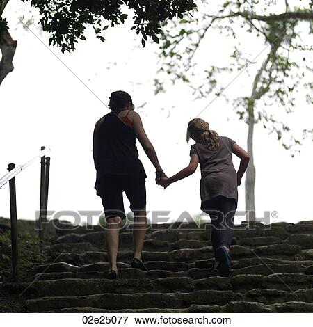 Mother and daughter holding hands walking up some steps. View Large Photo Image Stock Photo - Mother and daughter holding hands walking up some steps.. Fotosearch