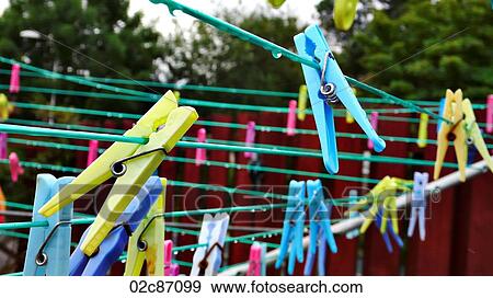 Stock Photo - Multi-colored clothes pins on an eco-friendly laundry line.. Fotosearch