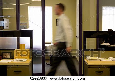 Stock Photo - Office worker urgently walking though office.. Fotosearch