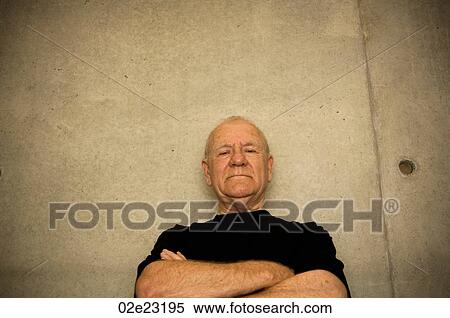 Stock Photography - Older intimidating man folding arms.. Fotosearch