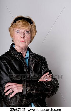 Stock Photography - Older senior woman in a black leather jacket and sunglasses.. Fotosearch