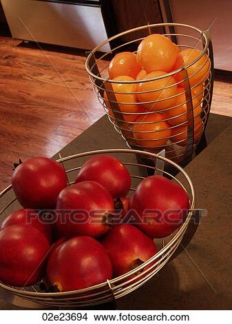 Oranges and pomegranates in kitchen baskets. View Large Photo Image Picture - Oranges and pomegranates in kitchen baskets.. Fotosearch