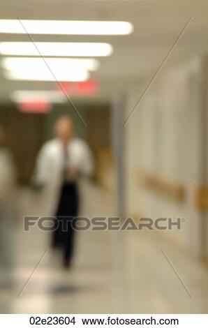 Out of focus doctor walking down hospital hallway. View Large Photo Image Picture - Out of focus doctor walking down hospital hallway.. Fotosearch