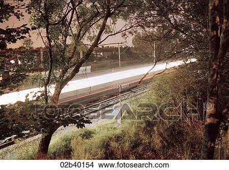 Picture - Passing speed train, viewed through trees. Fotosearch
