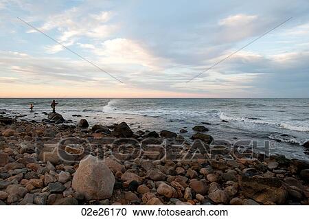 Stock Image - People fishing off the Hampton shoreline. Fotosearch