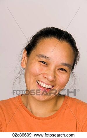 Stock Photo - Portrait headshot of happy Asian woman smiling.. Fotosearch