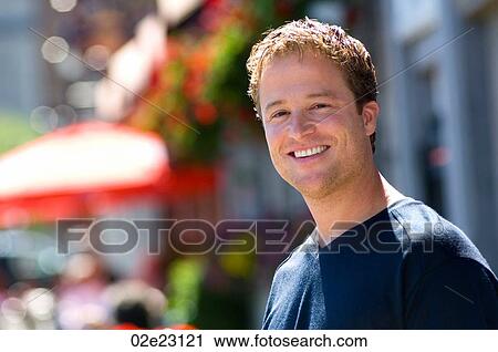 Stock Image - Portrait of man in front outdoor cafe.. Fotosearch