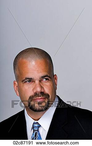 Stock Image - Portrait of serious business man in a suit and tie.. Fotosearch