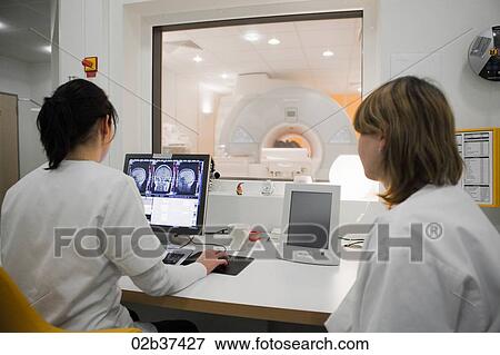 Radiology technicians monitoring MRI scan in progress View Large Photo Image Stock Photo - Radiology technicians monitoring MRI scan in progress. Fotosearch