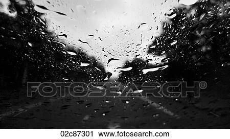 Raindrops on window with blurry road in background. View Large Photo Image Stock Image - Raindrops on window with blurry road in background.. Fotosearch