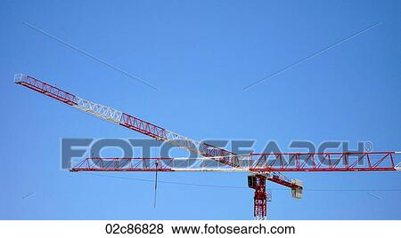 Stock Photo - Red and White construction cranes against blue sky.. Fotosearch