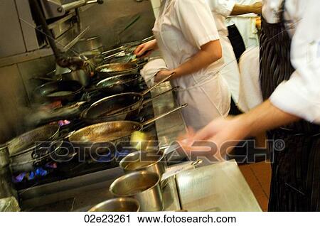 Restaurant kitchen staff busy at work at the stove. View Large Photo Image Stock Image - Restaurant kitchen staff busy at work at the stove.. Fotosearch
