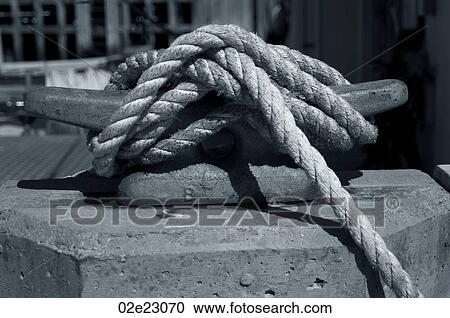 Stock Image - Rope tied to cleat on fishing pier.. Fotosearch