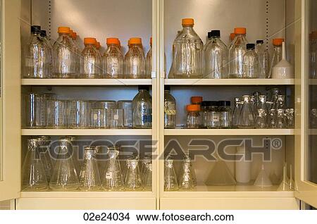 Picture - Scientific beakers and bottles in a cabinet.. Fotosearch