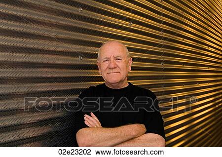 Senior man with arms folded in front of steel background. View Large Photo Image Stock Image - Senior man with arms folded in front of steel background.. Fotosearch