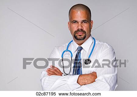 Stock Photography - Serious Doctor with stethoscope with arms folded.. Fotosearch