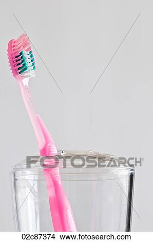 Single pink toothbrush in toothbrush holder. View Large Photo Image Picture - Single pink toothbrush in toothbrush holder.. Fotosearch