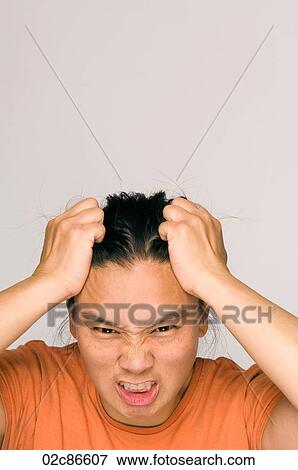 Stock Photo - Stressed out Asian woman holding head.. Fotosearch