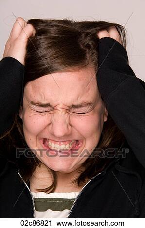 Stock Image - Stressed-out woman, holding head.. Fotosearch