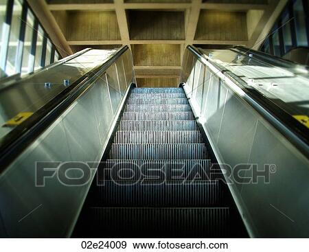 Stock Photo - Sunlight shining on ascending metal escalator.. Fotosearch