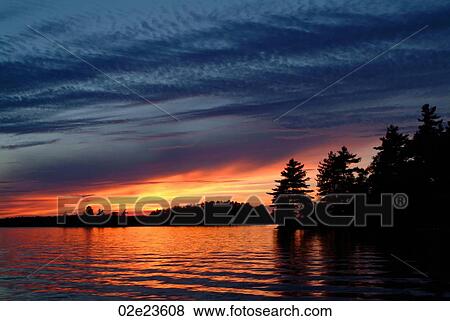 Sunset reflecting in a lake. View Large Photo Image Stock Photo - Sunset reflecting in a lake.. Fotosearch