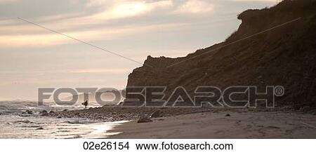 Surfer along the Hampton coastline View Large Photo Image Picture - Surfer along the Hampton coastline. Fotosearch