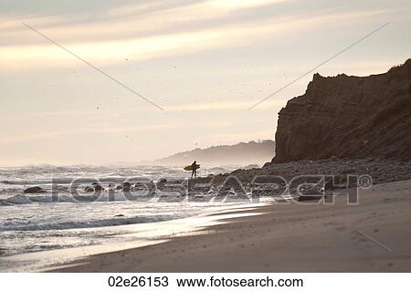Stock Image - Surfer along the Hampton coastline. Fotosearch