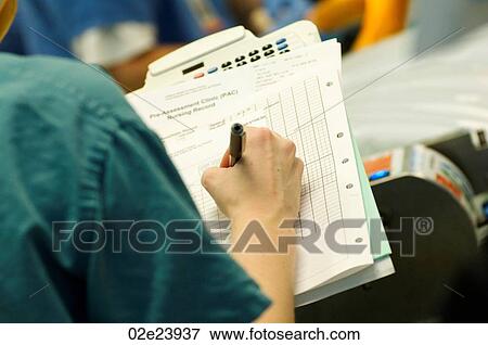 Stock Photo - Surgical nurse writing on patient chart.. Fotosearch