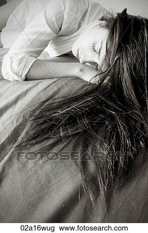 Teenage girl lies on bed with eyes closed View Large Photo Image Stock Image - Teenage girl lies on bed with eyes closed. Fotosearch
