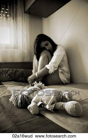 Teenage girl sits on a bed with a rag doll View Large Photo Image Stock Image - Teenage girl sits on a bed with a rag doll. Fotosearch