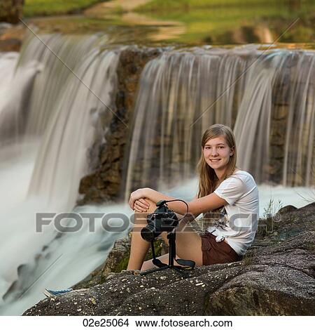 Teenage girl sitting at Privassion Creek holding a camera. View Large Photo Image Picture - Teenage girl sitting at Privassion Creek holding a camera.. Fotosearch