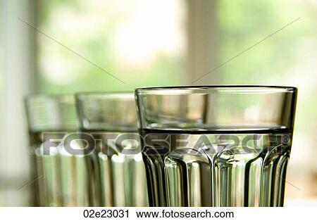 Three full clear glasses lined up with drinking water. View Large Photo Image Stock Image - Three full clear glasses lined up with drinking water.. Fotosearch