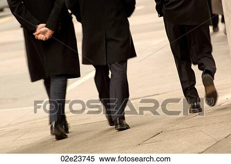 Stock Photography - Three men walking downtown wearing black coats.. Fotosearch