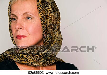 Stock Image - Tight face shot of mature woman wearing elegant head scarf.. Fotosearch