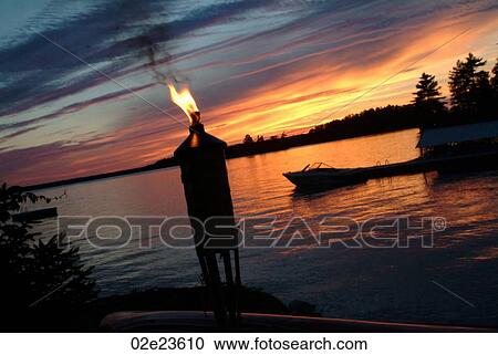 Tiki torch in-front of a lake. View Large Photo Image Stock Image - Tiki torch in-front of a lake.. Fotosearch