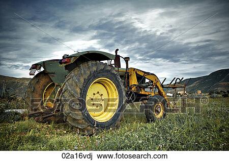 Stock Image - Tractor parked in rural landscape. Fotosearch