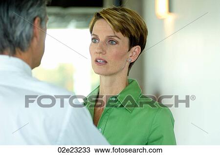 Two business colleagues interacting at the office. View Large Photo Image Stock Image - Two business colleagues interacting at the office.. Fotosearch