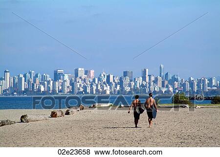 Two surfers walking on beach in Vancouver Canada. View Large Photo Image Stock Photo - Two surfers walking on beach in Vancouver Canada.. Fotosearch