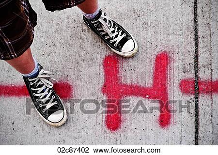 Urban youth with Converse high-tops standing beside spray painted H on sidewalk. View Large Photo Image Stock Image - Urban youth with Converse high-tops standing beside spray painted H on sidewalk.. Fotosearch