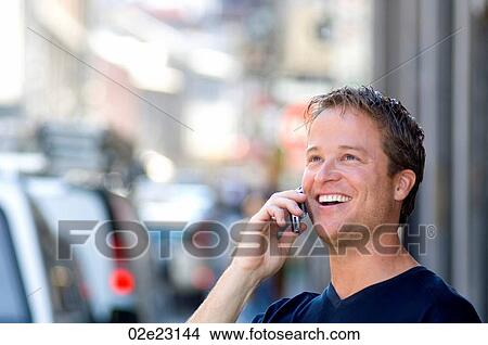 Picture - Very happy man talking his cellular phone.. Fotosearch