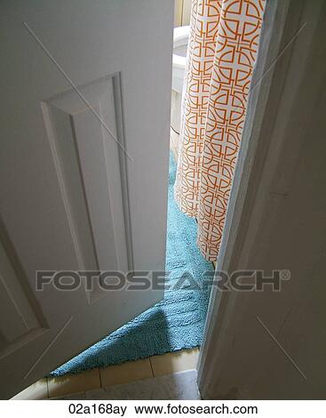 View through narrowly open door onto a blue rug and orange detailed curtain View Large Photo Image Stock Photo - View through narrowly open door onto a blue rug and orange detailed curtain. Fotosearch