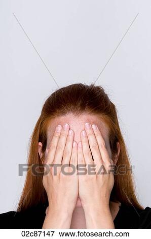 Stock Photo - Woman covering face with hands.. Fotosearch
