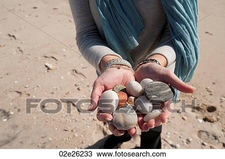 Woman holding a collection of pebbles View Large Photo Image Stock Image - Woman holding a collection of pebbles. Fotosearch