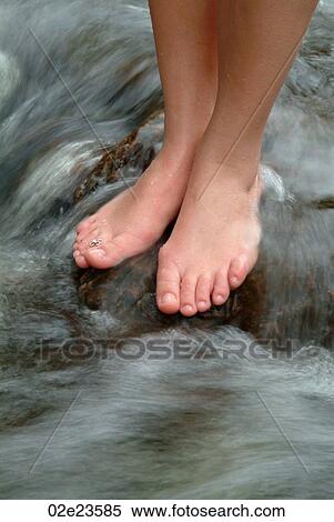 Women standing on a rock in a stream of moving water. View Large Photo Image Stock Photography - Women standing on a rock in a stream of moving water.. Fotosearch