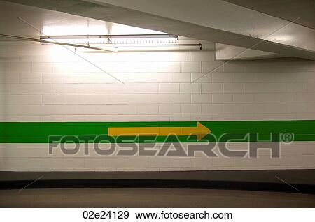 Yellow arrow pointing in parkade. View Large Photo Image Stock Photo - Yellow arrow pointing in parkade.. Fotosearch