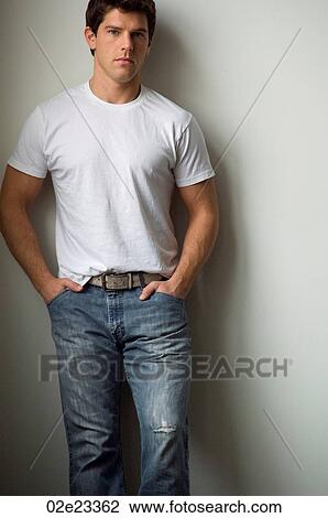 Young adult man leaning against white wall, wearing a white t-shirt. View Large Photo Image Stock Image - Young adult man leaning against white wall, wearing a white t-shirt.. Fotosearch