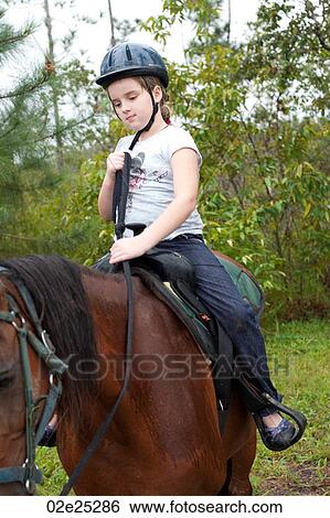 Stock Photograph - Young girl riding a horse at Mountain Pine Ridge Reserve in Belize. Fotosearch