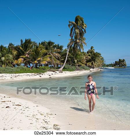 Young girl walking along beach at Belizean Isle in Belize View Large Photo Image Picture - Young girl walking along beach at Belizean Isle in Belize. Fotosearch