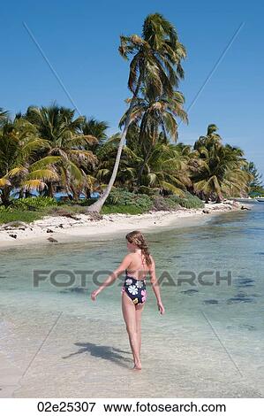 Young girl walking along beach at Belizean Isle in Belize View Large Photo Image Stock Photo - Young girl walking along beach at Belizean Isle in Belize. Fotosearch