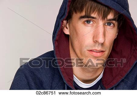Stock Image - Young male wearing hooded sweatshirt.. Fotosearch